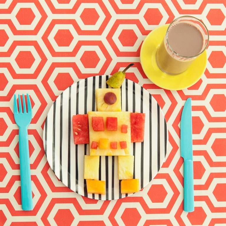 meyveli_robot_1984x1322_PT_pt_20210825_1.jpg meyvelerden yapılmış bir robot ve yanında bir bardak Nesquik